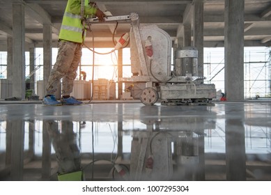 Construction worker produces the grout and finish wet concrete with a special tool. Float blades. For smoothing and polishing concrete, concrete floors