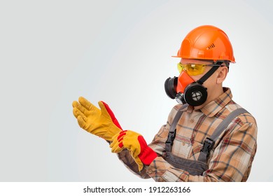 Construction Worker Putting On Protective Gloves Over Gray Background. Personal Safety Equipment.