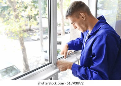 Construction worker putting sealing foam tape window in house