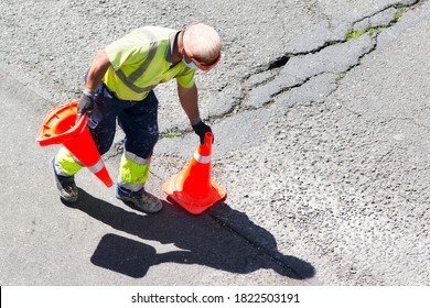 Construction Worker With Reflective Vest  And Road Traffic Cones  In Highway Site For Maintenance