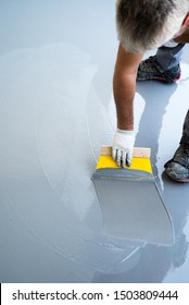 A Construction Worker Renovates Balcony Floor And Spreads Watertight Resin And Glue Before Chipping And Sealing