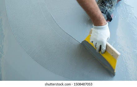 A Construction Worker Renovates Balcony Floor And Spreads Watertight Resin And Glue Before Chipping And Sealing