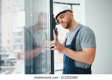 Construction worker repairing plastic window with screwdriver indoors, space for text. Banner design - Shutterstock ID 2113222481