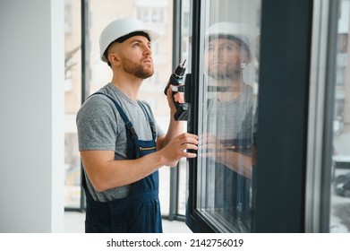 Construction worker repairing plastic window with screwdriver indoors, space for text. Banner design - Shutterstock ID 2142756019