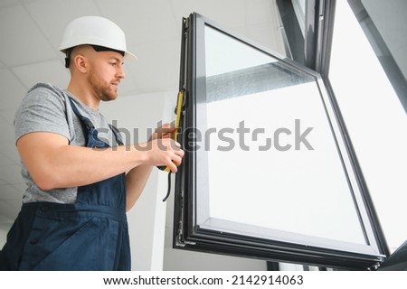 Construction worker repairing plastic window with screwdriver indoors, space for text. Banner design