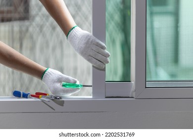 Construction Worker Repairing The Sliding Window.