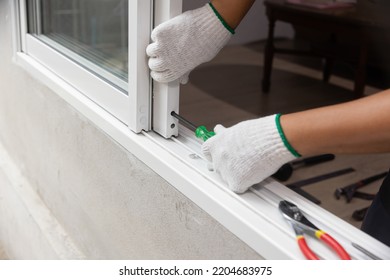 Construction worker repairing the sliding window. - Shutterstock ID 2204683975