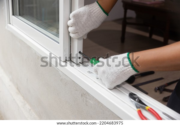 Construction worker\
repairing the sliding\
window.