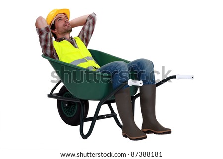 Construction worker resting in a wheelbarrow