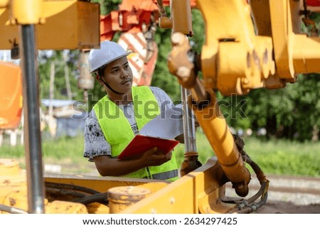 Construction Worker Reviewing Documents by Machinery