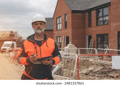 Construction Worker Reviewing Plans at New Home Development Site - Powered by Shutterstock