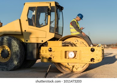 Construction worker revise excavator tire - Powered by Shutterstock