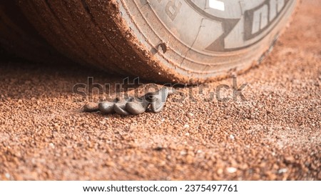 A construction worker rubber glove is placed on dirt ground under the heavy vehicle wheel road at construction worksite. Transportation accident scene concept.