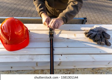 Construction Worker Secures Load On A Car Trailer With Tension Straps