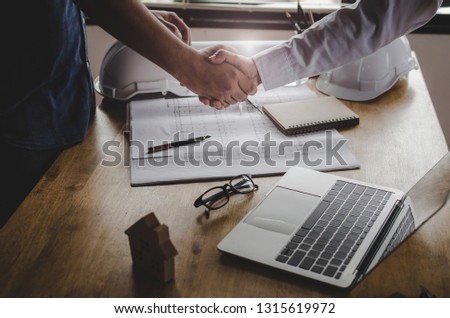 construction worker shaking hands with customer after finishing up business meeting to start up project contract in office center at construction site, home loan, contractor, engineering concept