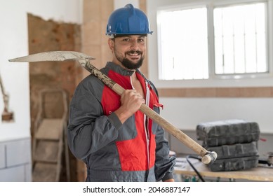 construction worker with shovel looks at camera with helmet smiling