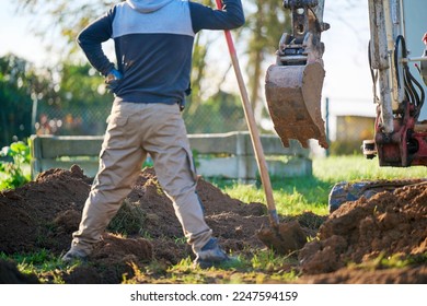 Construction worker in construction site.
Construction worker standing and watching bucket digger digging trench. - Shutterstock ID 2247594159