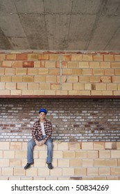 Construction worker sitting on brick wall