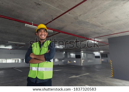 Construction worker smiling on building site. asian contruction worker at building site.