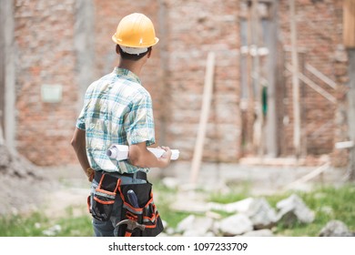 construction worker standing in front of the building site. shoot from the back