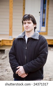 A construction worker standing in front of a new home