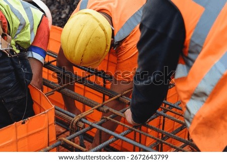 Construction worker steel fixer assembling rebar at building site