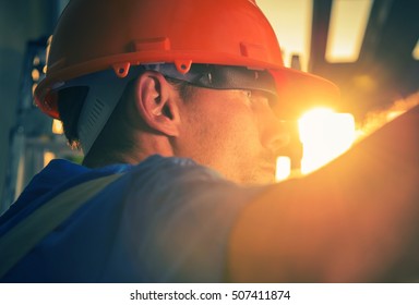 Construction Worker In The Sun. Caucasian Worker In His 30s Wearing Red Safety Helmet.