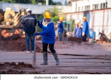 Construction worker sweepers soil debris with brush broom In the construction site - Powered by Shutterstock