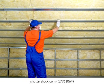 Construction worker thermally insulating house attic with mineral wool - Shutterstock ID 177610649