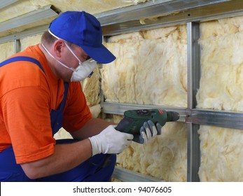 Construction worker thermally insulating house attic with mineral wool - Shutterstock ID 94076605