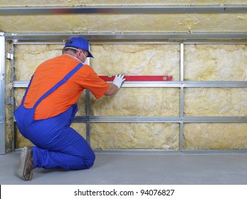 Construction worker thermally insulating house attic with mineral wool - Shutterstock ID 94076827