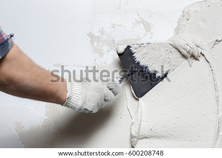 Construction worker with trowel plastering a wall