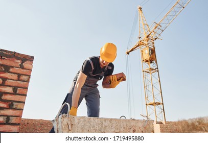 Construction worker in uniform and safety equipment have job on building.