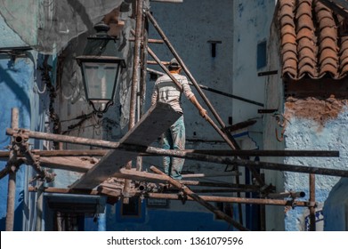 Construction worker unsafely working in the streets of Chefchaouen, Morocco