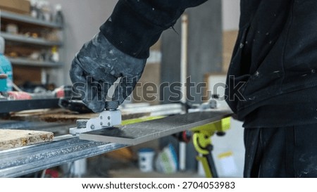 A construction worker uses a tile cutter to precisely cut a tile for a home renovation project