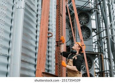 Construction Worker Using Chain Hoist in Silo Building - Powered by Shutterstock