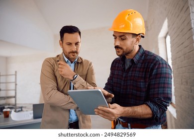 Construction worker using digital tablet with home owner during renovating process.  - Powered by Shutterstock