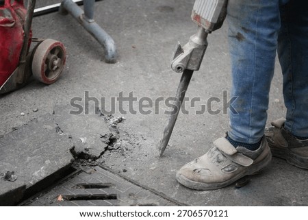 Construction worker using equipment on city street