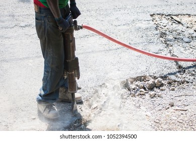 Construction Worker Using A Jack Hammer To Cut Concrete