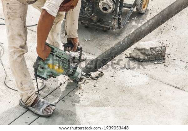 Construction worker using jackhammer drilling
concrete surface