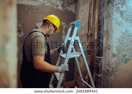 
Construction Worker Using a Ladder on the Work Site 
Contractor complies with safety regulations at work
