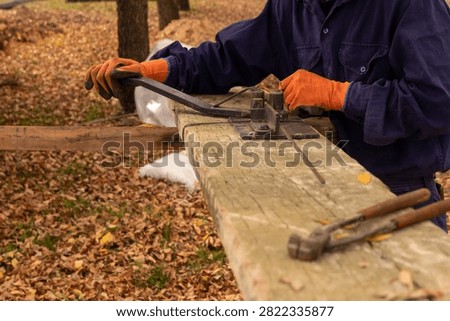 Construction worker using manual rebar bender to shape steel stirrups for concrete reinforcement