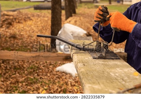 Construction worker using manual rebar bender to shape steel stirrups for concrete reinforcement