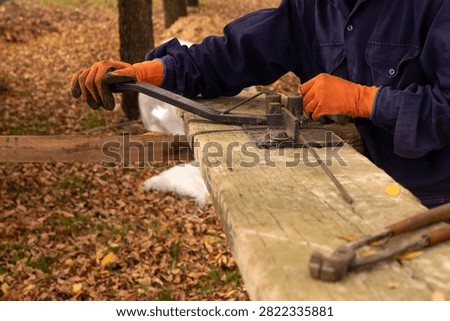 Construction worker using manual rebar bender to shape steel stirrups for concrete reinforcement