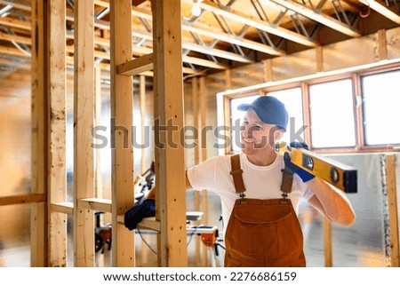 A Construction Worker Using Power Tool in Unfinished Basement of New Home