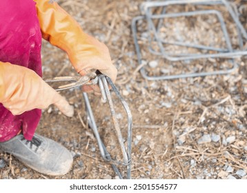 Construction worker using rebar wire to fasten together in struction site.