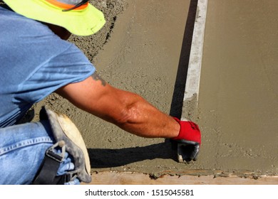 Construction Worker Is Using Steel Box On Concrete Slab To Level The Slab After Pouring Concrete. Worker Is Leveling Poured Concrete.