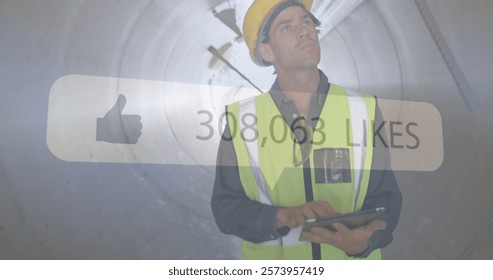 Construction worker using tablet, social media likes image over tunnel background. infrastructure, technology, digital, engineering, project, safety
