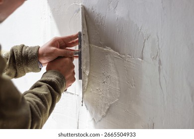 Construction worker is using a trowel to apply plaster on a wall, creating a textured surface during a home renovation or construction project - Powered by Shutterstock - Get 15% off with code: PIKWIZARD15