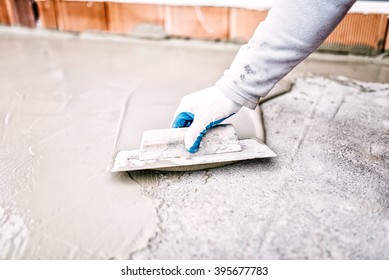 Construction Worker Using Trowel And Mason's Float For Hydroisolating And Waterproofing House